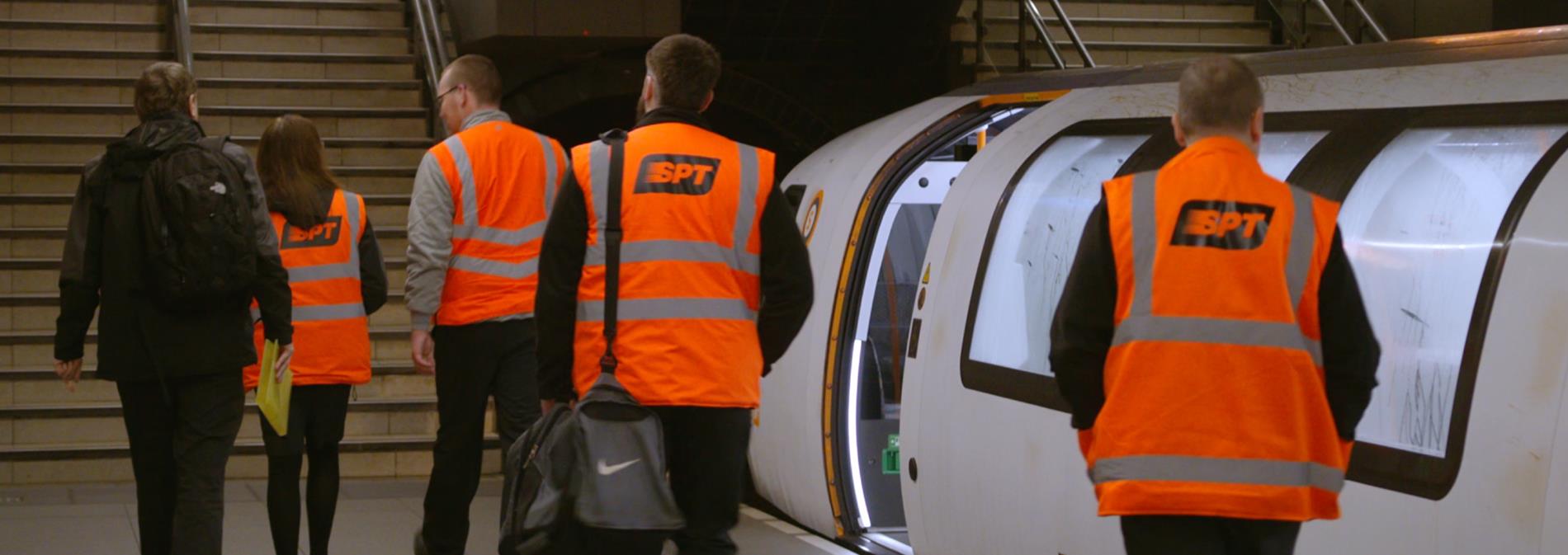 Four Subway workers alighting a Subway train